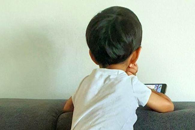 Parvinder's son looking at mobile device